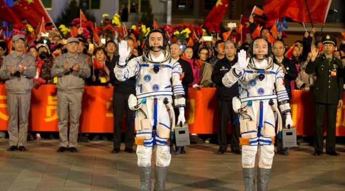 Chinese astronauts Jing Haipeng, Chen Dong wave before the launch of Shenzhou-11 manned spacecraft, in Jiuquan China launches longest-ever manned space mission